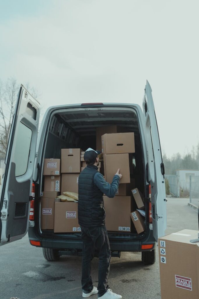 Man Putting the Brown Cardboard Boxes Inside the Van 